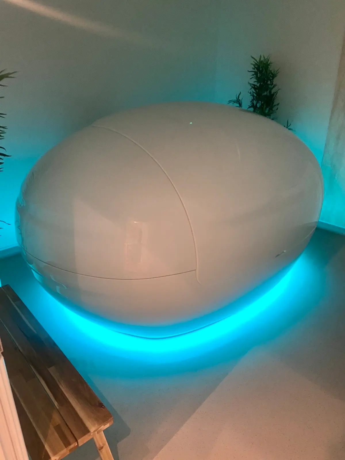 A closed Orbit float pod surrounded by soft aqua light