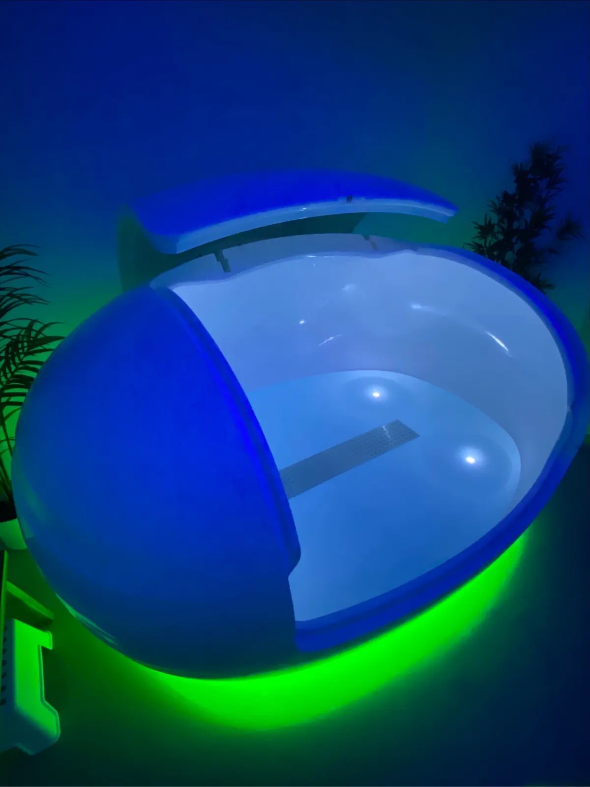 The open Orbit float pod illuminated in blue and green