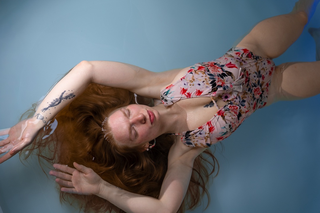Client floating with arms relaxed above her head