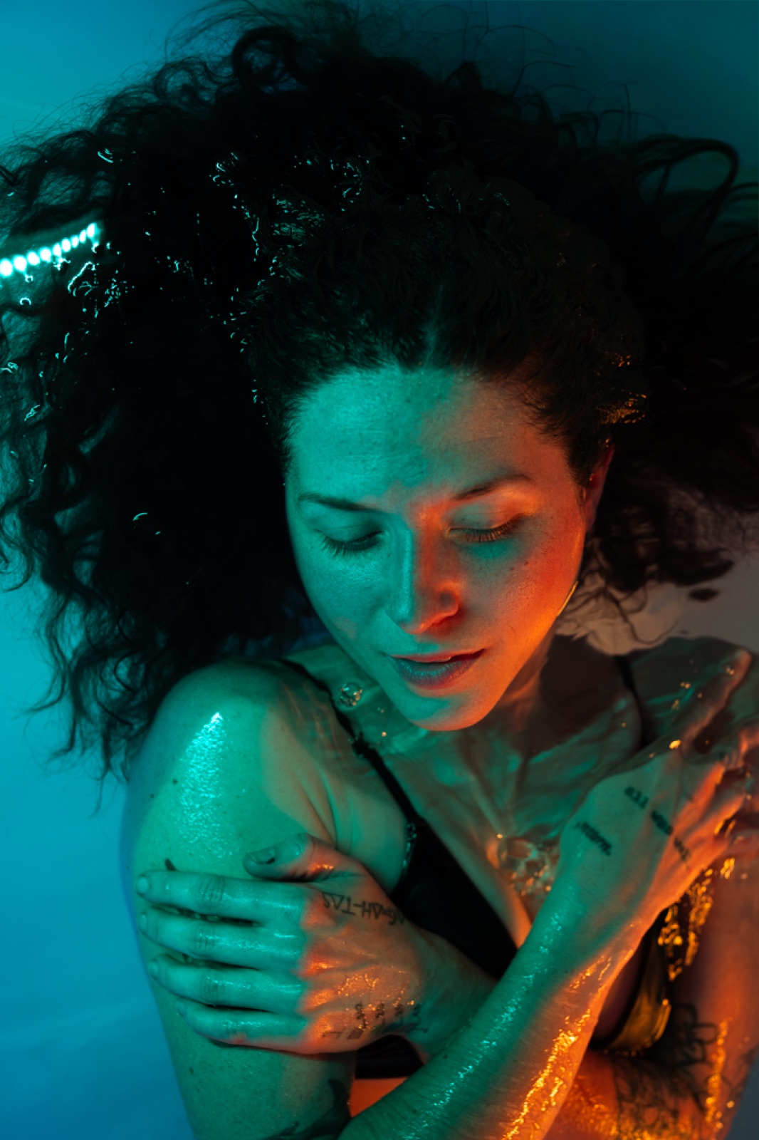 FLOAT ONE guest floating calmly under aqua and amber light