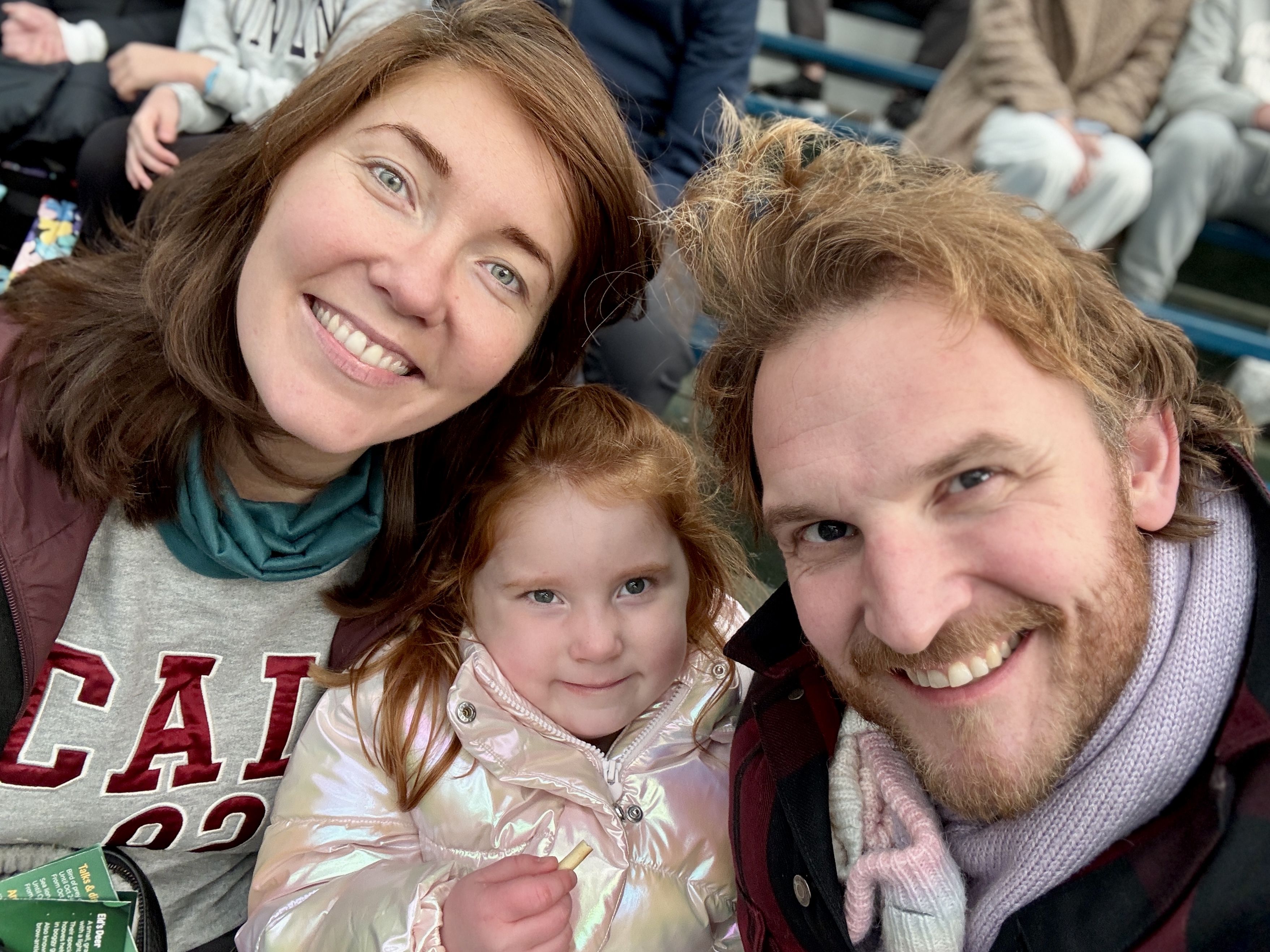 A family of three smiling together.